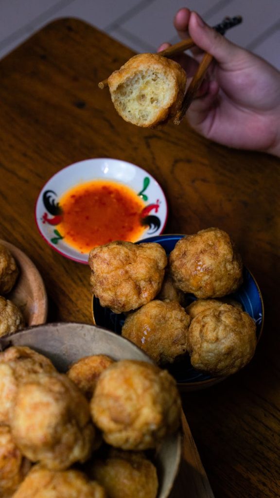 Delicious Indonesian fried snacks served with a spicy chili sauce, perfect for an authentic culinary experience.